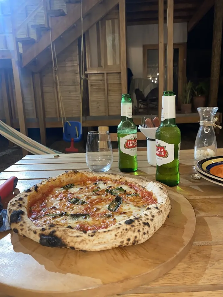 Margherita napolitana sobre tabla de madera, con una Stella Artois al atardecer